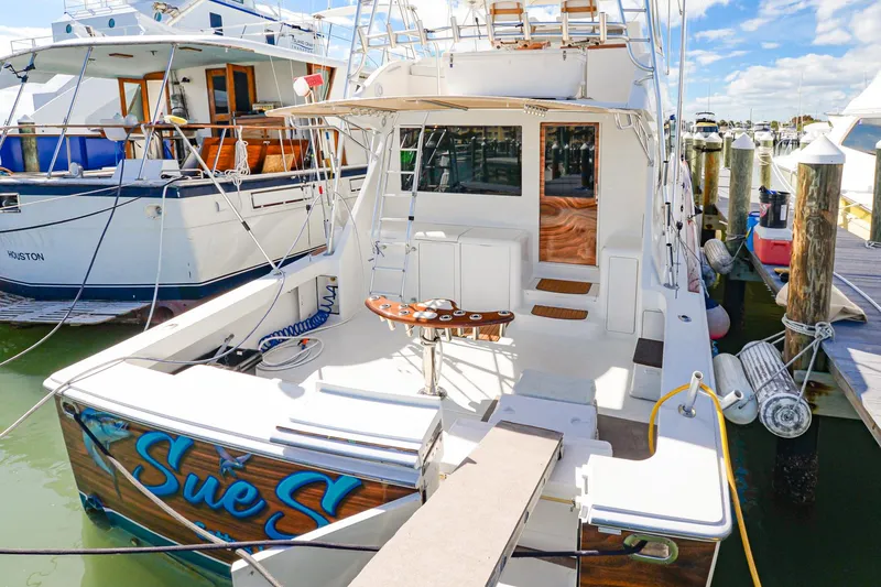 The Image of 1999 Viking 55 Convertible yacht docked, featuring spacious deck and fishing equipment. - 0