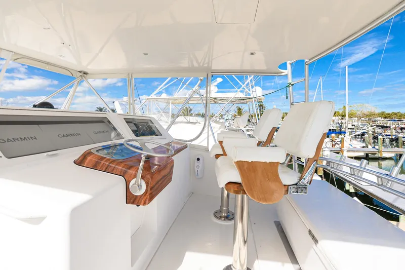 Slide: The Image of Helm of 1999 Viking 55 Convertible yacht with white seating and navigation equipment. - 13
