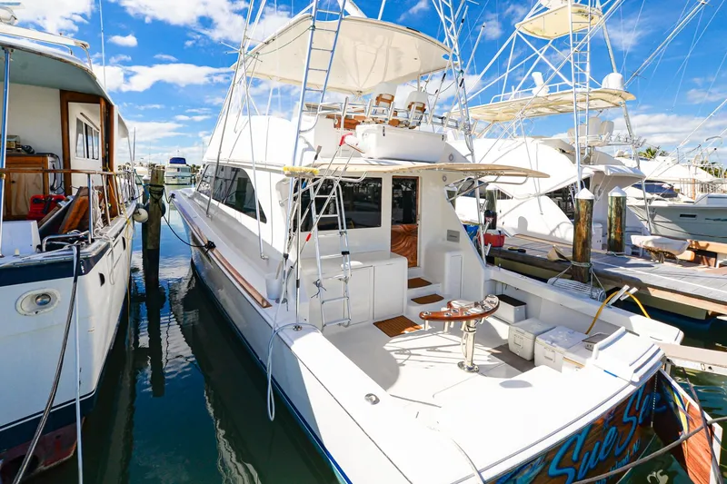 Slide: The Image of 1999 Viking 55 Convertible yacht docked at marina under clear blue sky. - 2