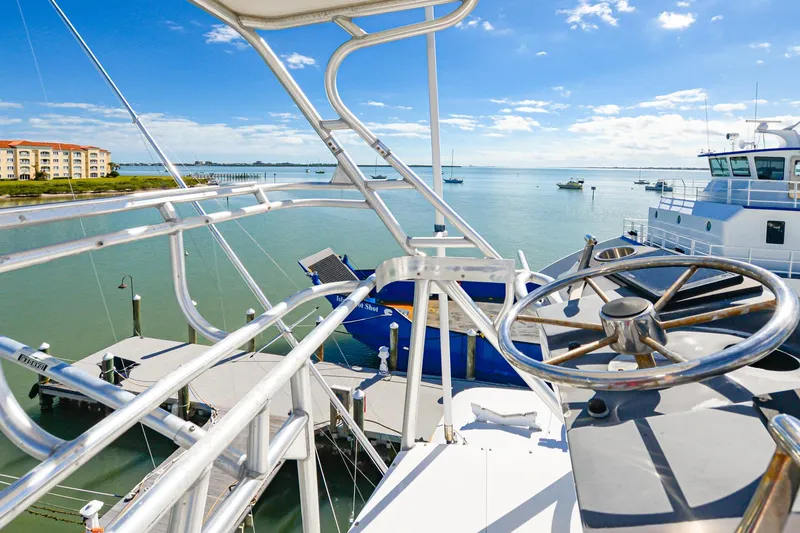 Slide: The Image of 1999 Viking 55 Convertible yacht helm with ocean view and docked boats. - 25