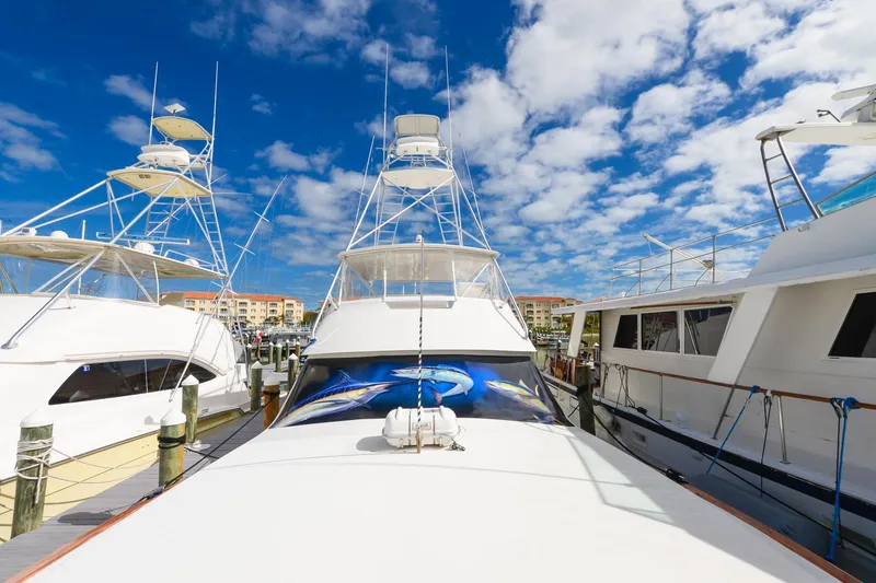 Slide: The Image of 1999 Viking 55 Convertible yacht docked under a vibrant blue sky. - 29