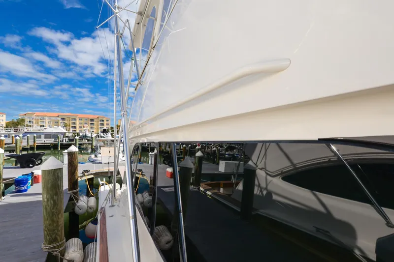 Slide: The Image of 1999 Viking 55 Convertible yacht docked at marina under blue sky. - 32