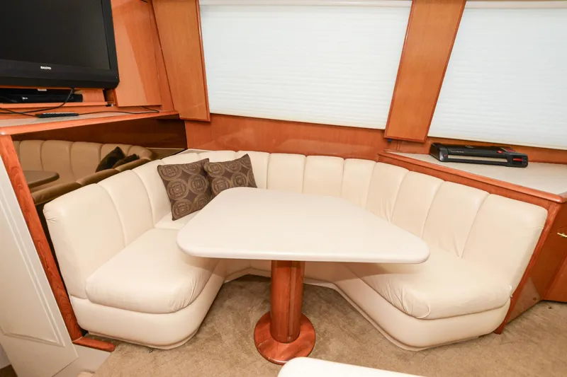 Slide: The Image of Cozy dining area in 1999 Viking 55 Convertible yacht with cream seating and wooden accents. - 37