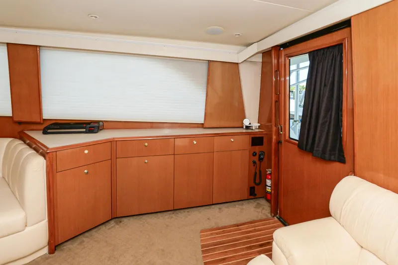 Slide: The Image of Interior of 1999 Viking 55 Convertible yacht with wooden cabinetry and beige seating. - 38