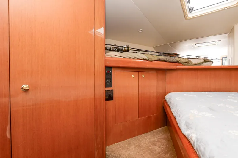 Slide: The Image of Interior cabin of 1999 Viking 55 Convertible yacht with wooden paneling and bed. - 48