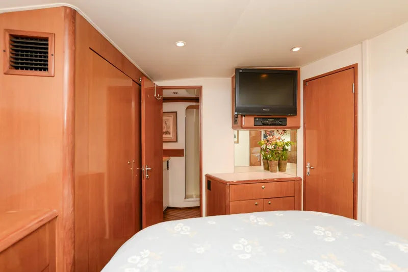 Slide: The Image of 1999 Viking 55 Convertible yacht interior with TV, wooden cabinetry, and floral decor. - 49