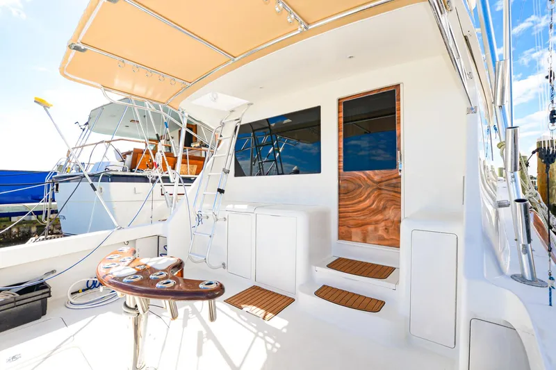 Slide: The Image of 1999 Viking 55 Convertible yacht deck with seating and ladder, showcasing luxury marine design. - 6