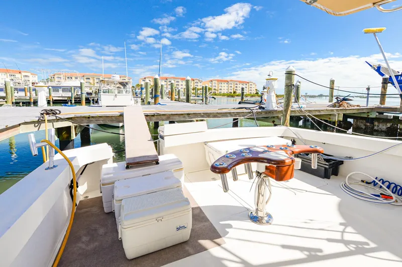 Slide: The Image of 1999 Viking 55 Convertible yacht docked at a marina under a clear blue sky. - 9