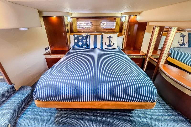 Slide: The Image of Luxurious 2005 Sea Ray 550 Sedan Bridge cabin with striped bedding and nautical decor. - 23