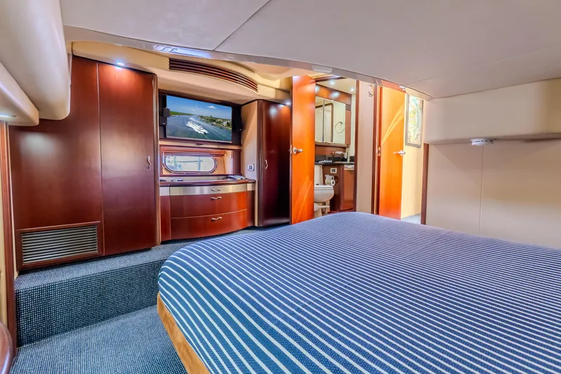 Slide: The Image of Luxurious cabin interior of 2005 Sea Ray 550 Sedan Bridge yacht with striped bedding. - 25