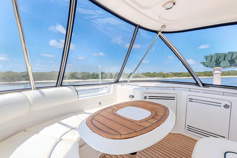 Slide: The Image of 2005 Sea Ray 550 Sedan Bridge interior with panoramic windows and elegant wooden table. - 40