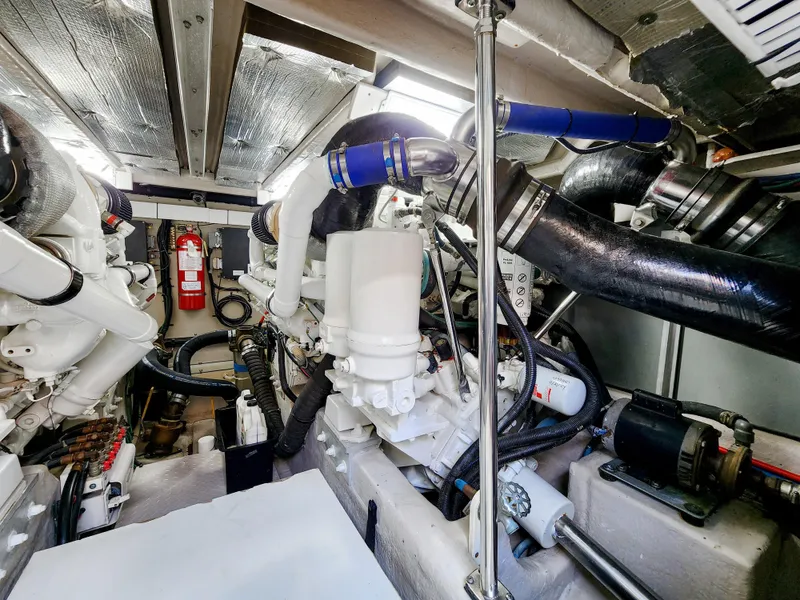Slide: The Image of Engine room of 2005 Sea Ray 550 Sedan Bridge yacht, showcasing mechanical components and fire extinguisher. - 44