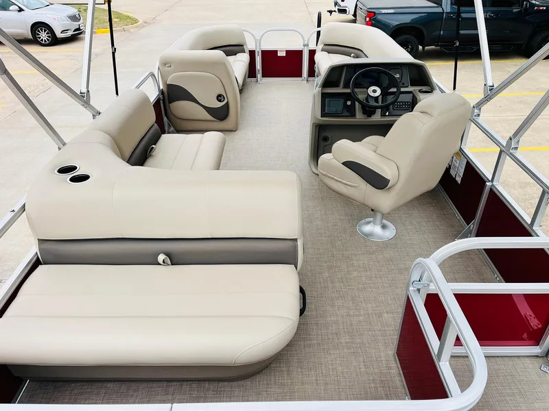 Slide: The Image of 2025 Sun Tracker Party Barge 18 DLX interior with beige seating and steering console. - 11