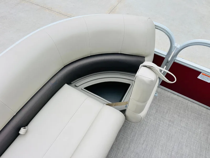 Slide: The Image of 2025 Sun Tracker Party Barge 18 DLX interior seating with beige upholstery and storage compartment. - 16