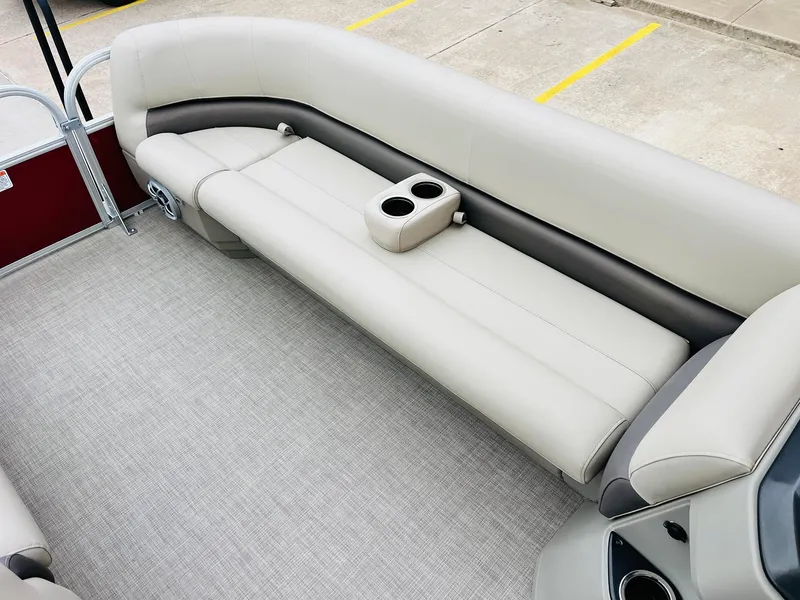 Slide: The Image of 2025 Sun Tracker Party Barge 18 DLX interior with beige seating and cup holders. - 18