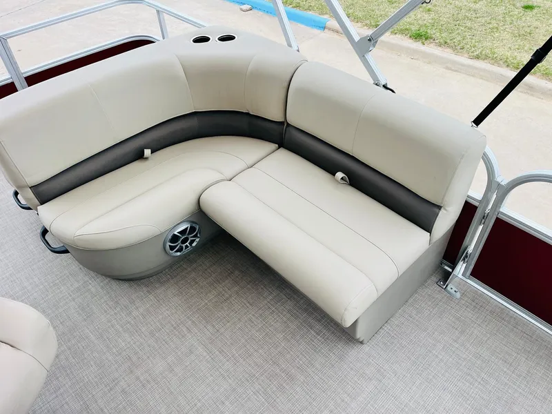 Slide: The Image of 2025 Sun Tracker Party Barge 18 DLX interior seating with beige upholstery and speaker. - 24