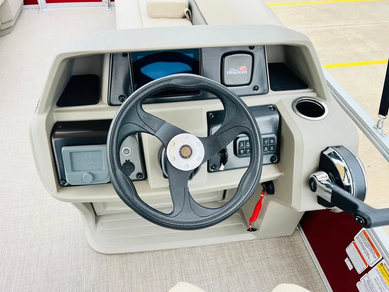 Slide: The Image of 2025 Sun Tracker Party Barge 18 DLX steering console with controls and cup holder. - 28