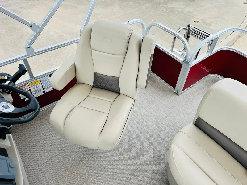 Slide: The Image of 2025 Sun Tracker Party Barge 18 DLX interior with beige seating and steering wheel. - 32