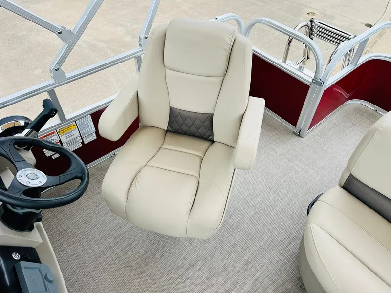 Slide: The Image of 2025 Sun Tracker Party Barge 18 DLX interior with beige captain's chair and steering wheel. - 33