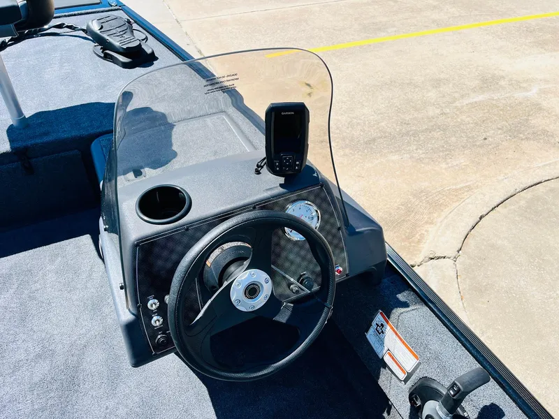 Slide: The Image of 2025 Tracker Bass Tracker Classic XL boat dashboard with steering wheel and mounted device. - 17
