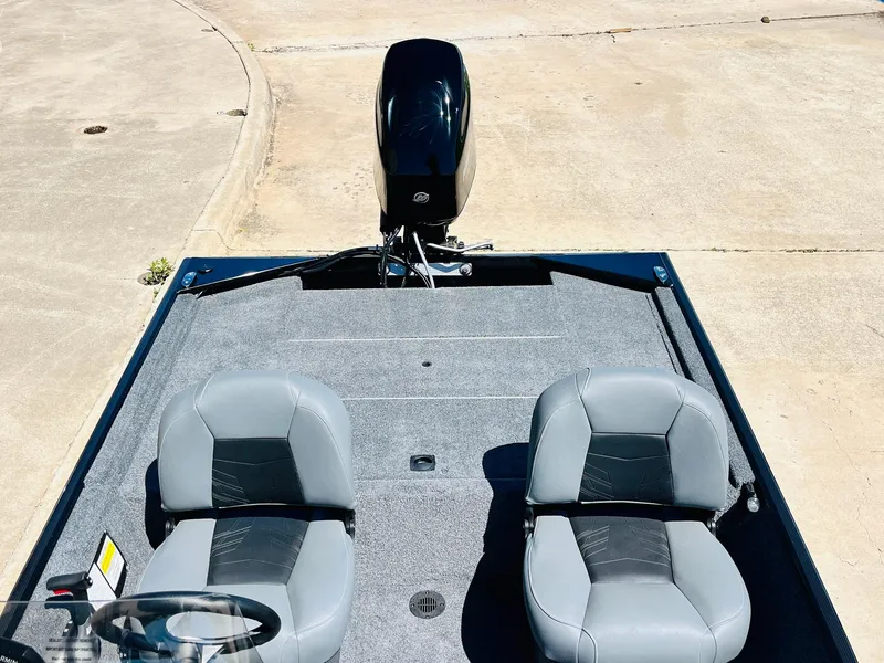 Slide: The Image of 2025 Tracker Bass Tracker Classic XL boat with dual seats and motor, parked on concrete. - 20