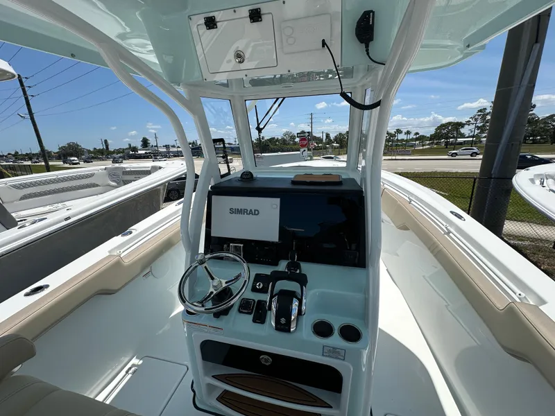 Slide: The Image of 2025 Sea Pro 292 Offshore boat cockpit with steering wheel and Simrad navigation system. - 4