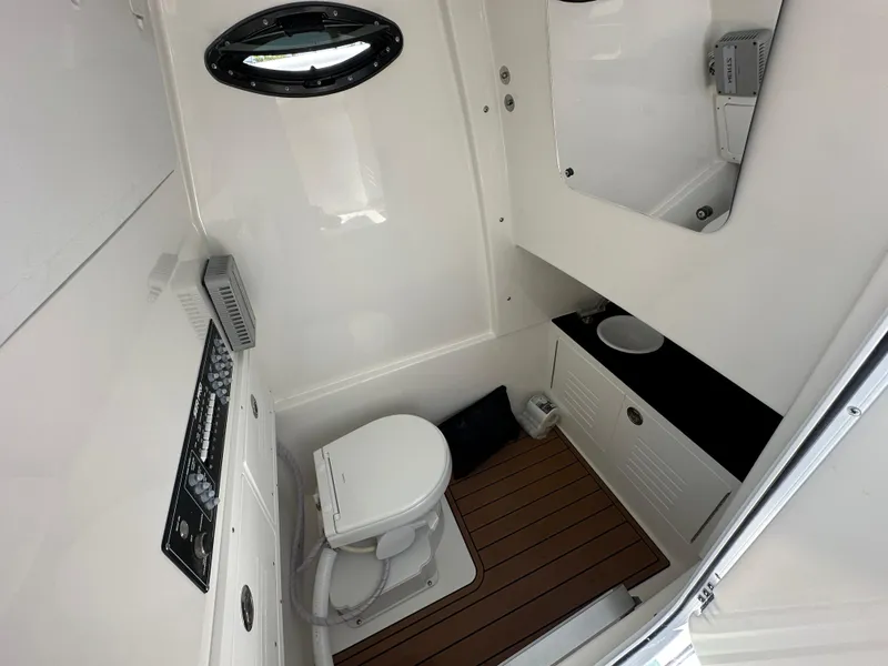 Slide: The Image of 2025 Sea Pro 292 Offshore boat bathroom with toilet, sink, and wood flooring. - 9