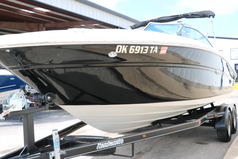 Slide: The Image of 2004 Sea Ray 220 Select boat on trailer, black hull, parked outdoors. - 10