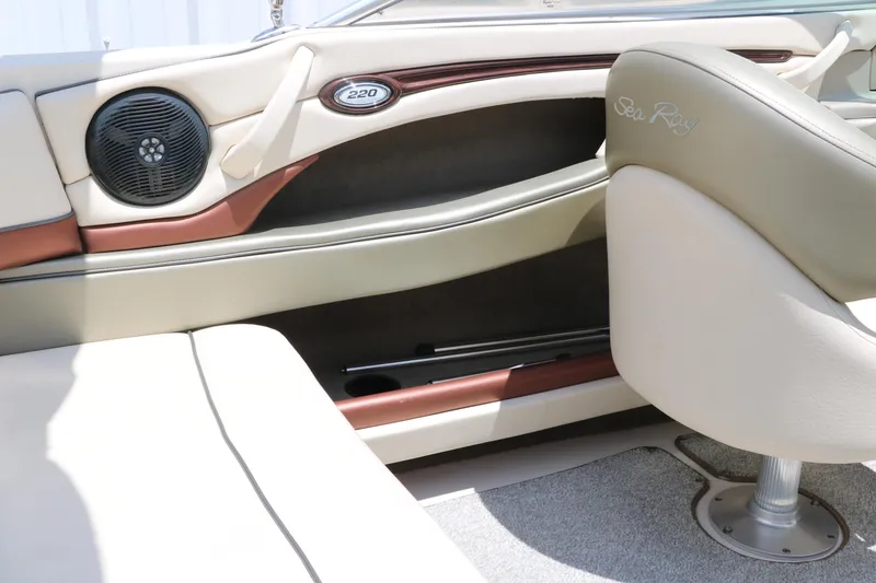 Slide: The Image of Interior of a 2004 Sea Ray 220 Select boat, featuring beige seating and speaker system. - 25