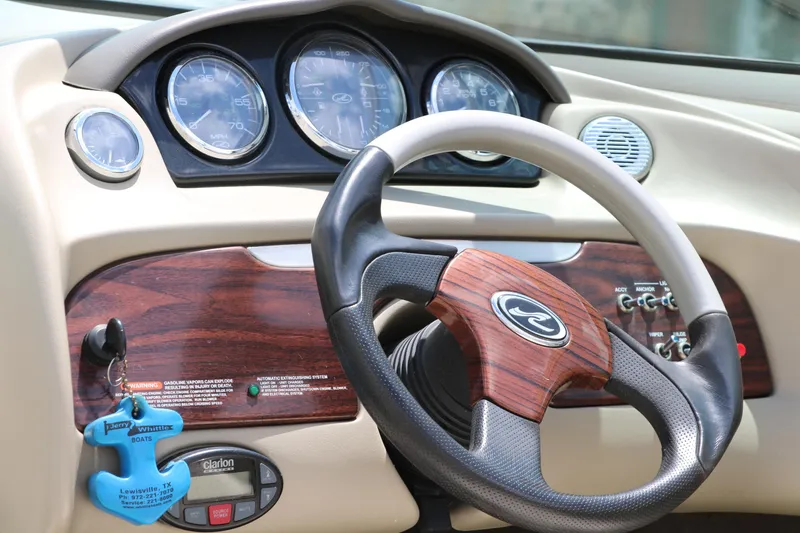 Slide: The Image of Dashboard of 2004 Sea Ray 220 Select boat with wood accents and steering wheel. - 30
