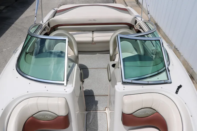 Slide: The Image of 2004 Sea Ray 220 Select boat interior with beige and brown seating, open windshield. - 33