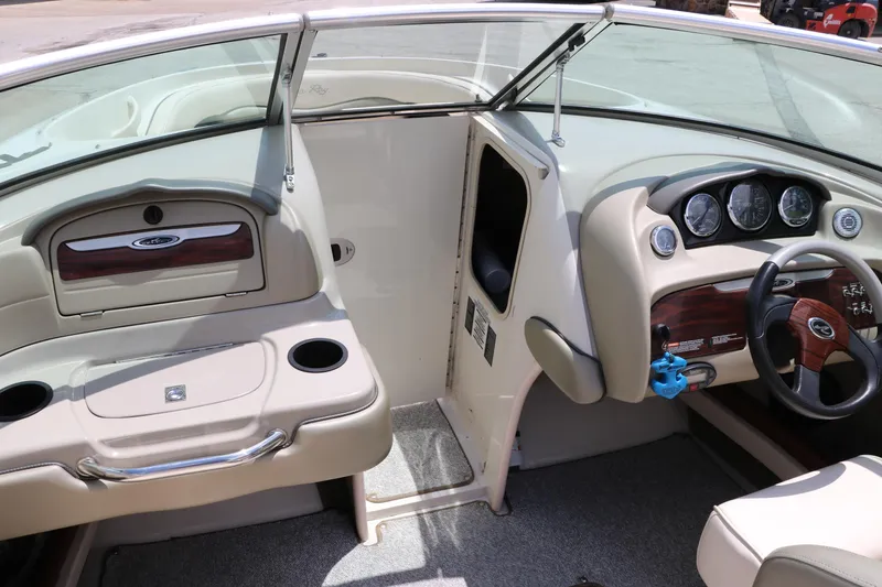 Slide: The Image of 2004 Sea Ray 220 Select boat interior with steering wheel, dashboard, and seating area. - 38