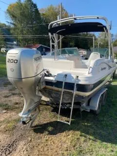 Slide: The Image of 2002 Hurricane 217 Sundeck boat with Honda 200 outboard motor, parked on grass. - 5