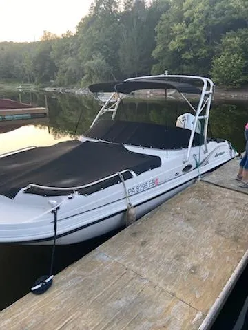 Slide: The Image of 2002 Hurricane 217 Sundeck boat docked on a calm lake with lush greenery. - 6