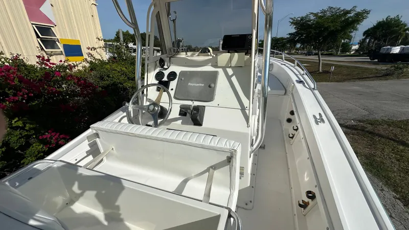 Slide: The Image of 1998 Mako 232 Center Console boat with steering wheel and seating, docked outdoors. - 3