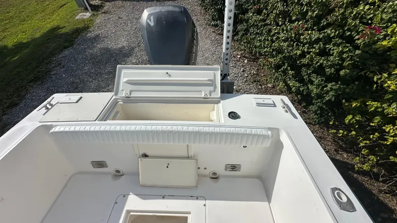 Slide: The Image of 1998 Mako 232 Center Console boat interior with open storage compartment and outboard motor. - 7