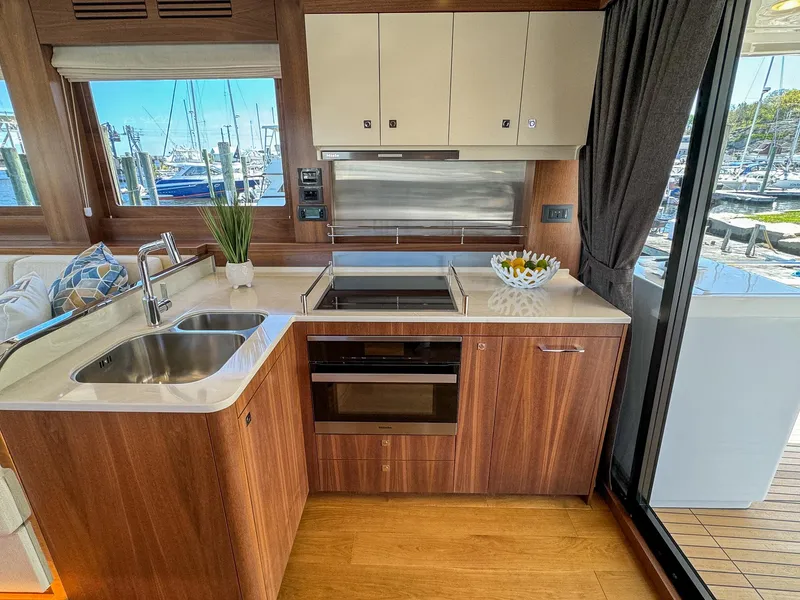 Slide: The Image of Luxurious 2024 Sirena 58 Flybridge yacht kitchen with modern appliances and elegant wood finish. - 39