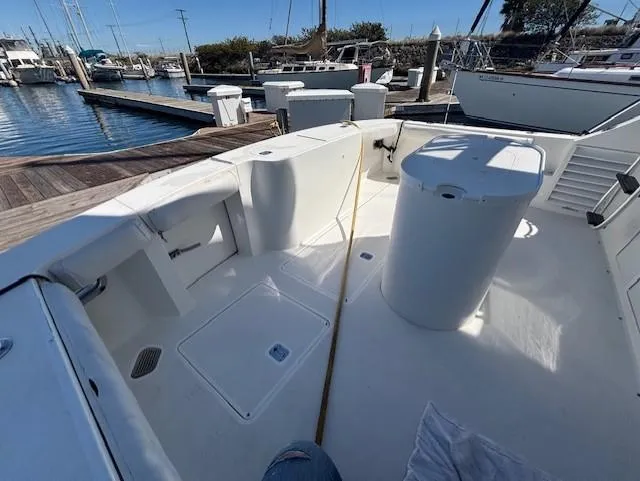 Slide: The Image of 2007 Jersey Cape 44 CNV boat docked at marina, showcasing spacious deck layout. - 12