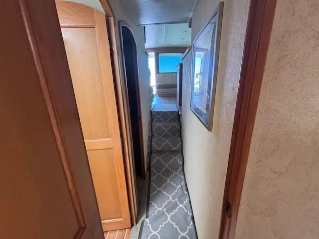 Slide: The Image of Narrow hallway inside 2007 Jersey Cape 44 CNV boat, featuring wooden doors and patterned carpet. - 17