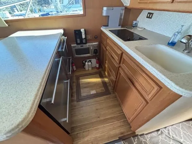 Slide: The Image of 2007 Jersey Cape 44 CNV yacht kitchen with modern appliances and wooden cabinetry. - 22