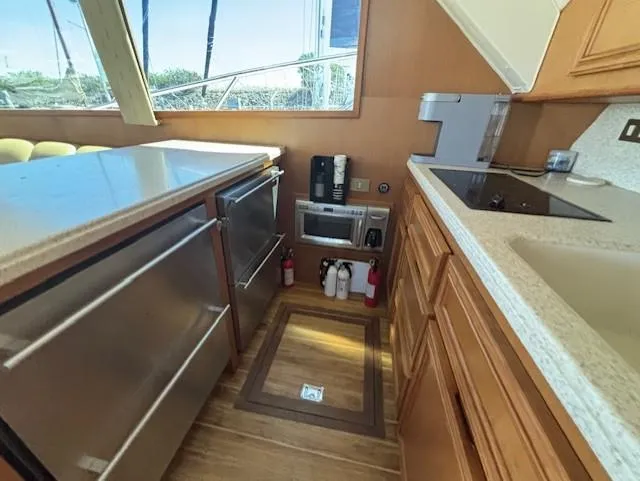 Slide: The Image of 2007 Jersey Cape 44 CNV yacht kitchen with modern appliances and wooden cabinetry. - 25
