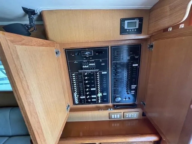 Slide: The Image of Electrical panel inside a 2007 Jersey Cape 44 CNV boat with open wooden cabinet doors. - 30