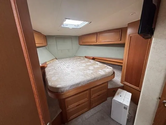 Slide: The Image of 2007 Jersey Cape 44 CNV cabin interior with bed and wooden storage cabinets. - 44