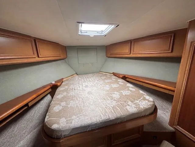Slide: The Image of 2007 Jersey Cape 44 CNV cabin interior with bed and wooden storage cabinets. - 45