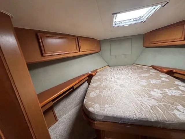 Slide: The Image of 2007 Jersey Cape 44 CNV cabin interior with bed and wooden storage cabinets. - 46