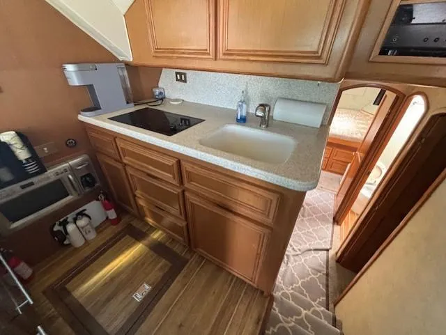 Slide: The Image of 2007 Jersey Cape 44 CNV yacht interior with kitchen, wooden cabinets, and modern appliances. - 49