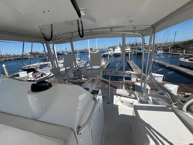 Slide: The Image of 2007 Jersey Cape 44 CNV yacht interior with marina view, featuring helm and seating area. - 6
