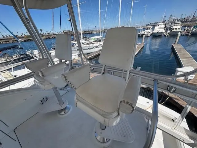 Slide: The Image of 2007 Jersey Cape 44 CNV boat helm with white captain chairs at marina. - 7