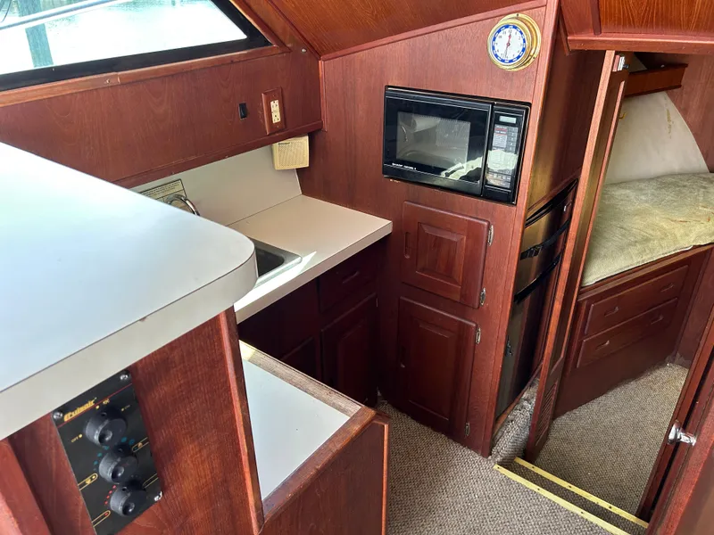 Slide: The Image of Interior of 1990 Albemarle 325 Convertible boat with kitchenette and sleeping area. - 13
