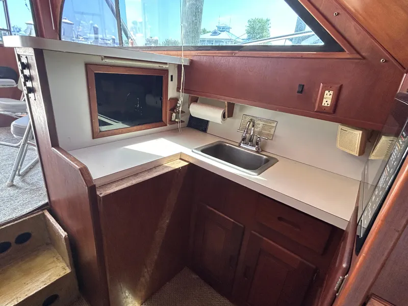 Slide: The Image of 1990 Albemarle 325 Convertible boat interior with compact kitchen and sink area. - 14